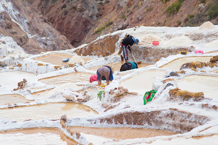 从秘鲁乌班巴谷马拉斯的梯田盐中手动提取矿物质背景图片