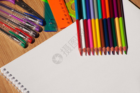 彩色铅笔钢笔木制桌子上有图片