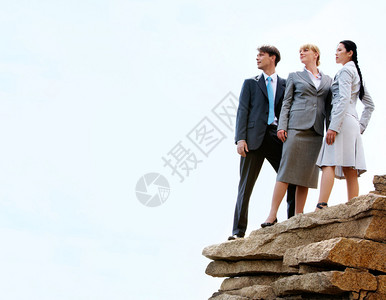 三个商业伙伴站在山顶上面天上有云彩的照图片