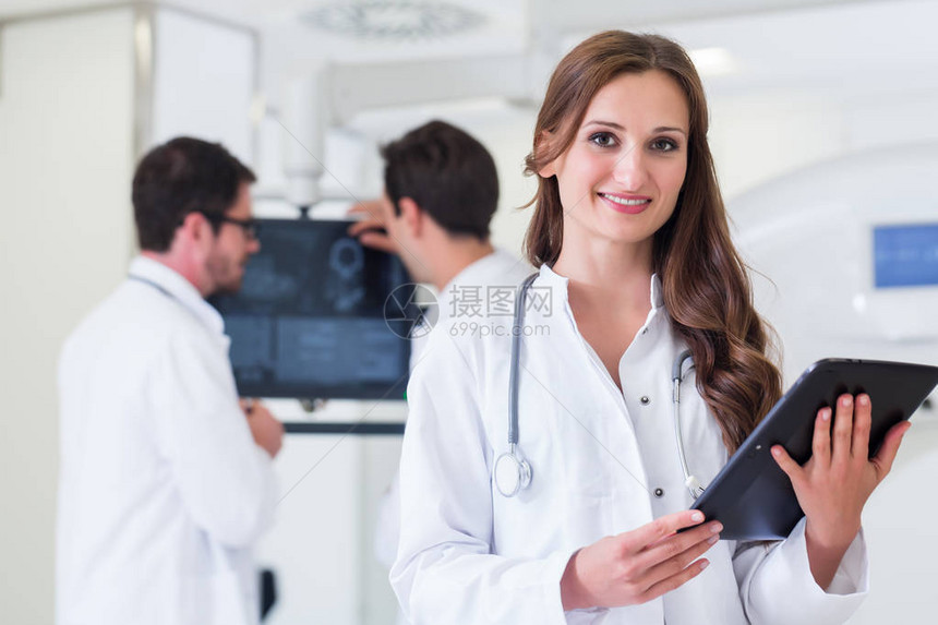 医生和同事在CT机器医院站着的医生图片