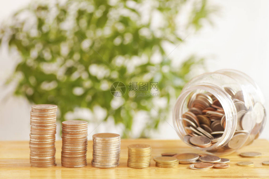 用塑料罐子堆在木桌上的钱币图片