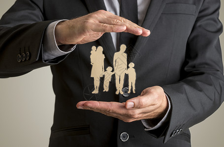 商人保护家庭剪影与父亲母亲婴儿和两个孩子用他的双手在人寿保险和安图片