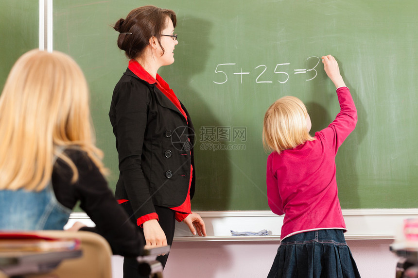 教育年轻女教师与学生以他的小学或图片