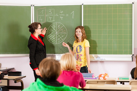 教育年轻女教师与学生以他的小学或图片