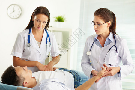 检查病人寻找疼痛来源的女执业女医生对图片