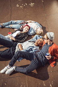 青少年群体躺在一起睡在滑板公园的高角图片
