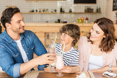 快乐的年轻家庭在咖啡馆喝奶图片