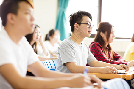 与同学们一起坐在一起的男大学生笑图片