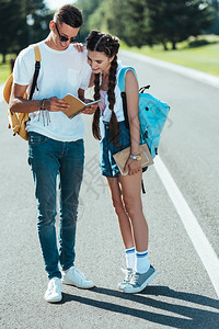 带着背包看着公园笔记本的少年男女儿童在公图片