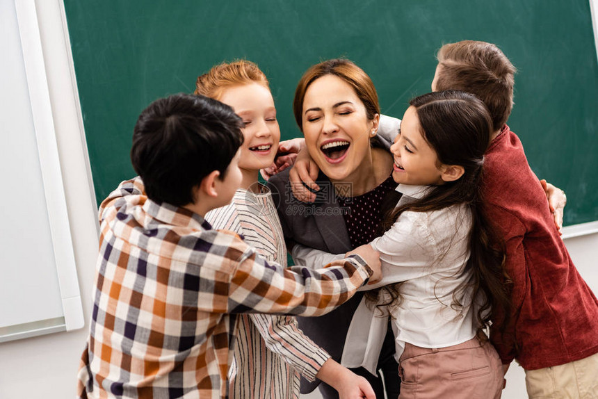 在教室黑板前拥抱老师的快乐学图片