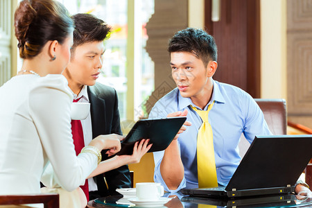 三名亚洲华人办公室人员或商人和女商人在酒店大堂举行商务会议图片