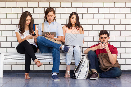 一群大学生坐在学校走廊的一席长椅上图片