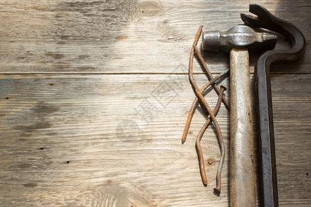 旧的生锈钉子和锤子木制背景上的钉子拉图片
