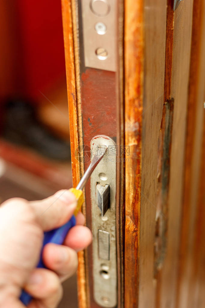 锁匠用螺丝刀安装门锁图片