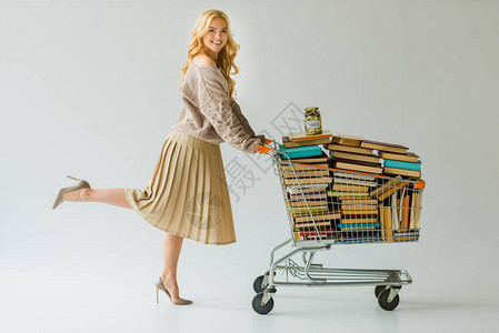 漂亮女人推着装满书的购物车图片