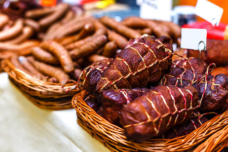 柳条筐里的熏肉和香肠在市场上出售图片