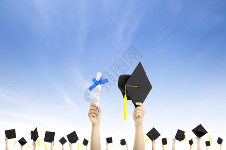手拿着云背景的毕业帽和文凭证书图片