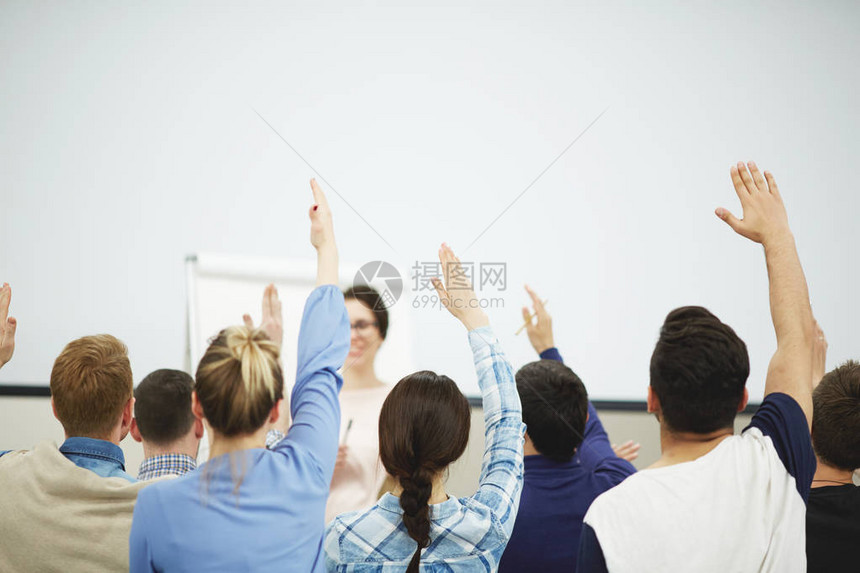 一群热心的学生举手坐在教室里图片