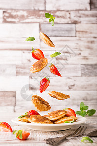 与酸奶迷你煎饼poffertjes配有飞食成份煎饼草莓和薄荷图片