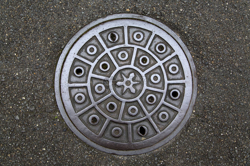 日本街道上的圆形钢井盖图片