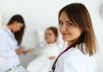 微笑的女医生在查房期间填写患者病史列表图片