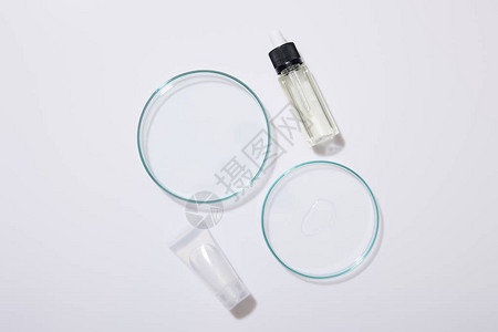 实验室灰底玻璃器件化妆管和一瓶油的顶端背景图片