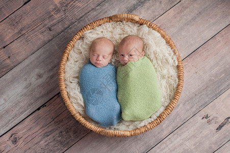四周大的兄弟双胞胎男婴裹在浅蓝色和绿色的包裹中图片