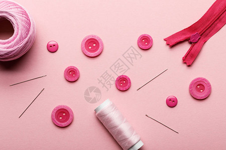 以粉红色隔离的衣服按钮线圈和缝纫用图片