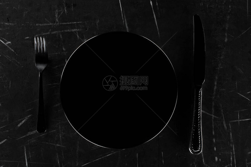 黑色圆板上方的黑圆形面用叉子和图片