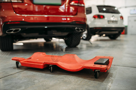 自动滚动素材在汽车底部工作的滚动台车在自动服务中背景