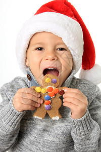 五岁的男孩戴着圣诞老人的帽子吃图片