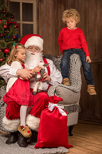 圣诞老人坐在灰色的椅子上带背景图片