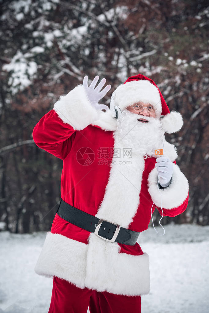 圣诞老人在听耳机音乐的同时跳舞并用图片