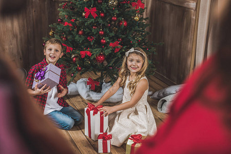 可爱的孩子在圣诞树附近的地板上图片