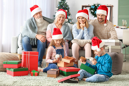 小孩和家人在家打开圣诞礼物图片