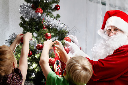 带着圣诞老人的小孩在圣诞树图片