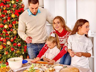 幸福的家庭与子女和父母在圣诞树附图片