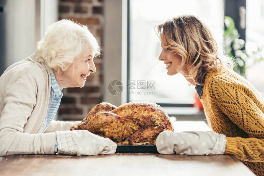 快乐的年老母亲和女儿与美味的图片