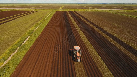 拖拉机的农民用苗床中耕机在农田里准备土地拖拉机犁地农业加工土地耕作农民准备土地背景图片