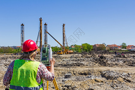 妇女测量在建筑工地测量水平测量员确保在进行大型建筑项目之前图片