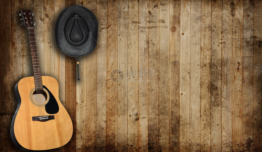 旧谷仓背景下的牛仔帽和吉他图片