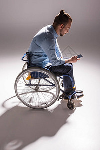 残疾人使用智能手机坐在轮椅图片