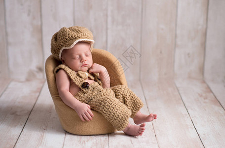 鹤唳九天九天大的新生男婴穿着钩针编织的小西装背景
