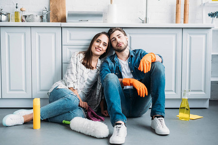 夫妻坐在地板上笑着的情侣在厨房打扫之后图片