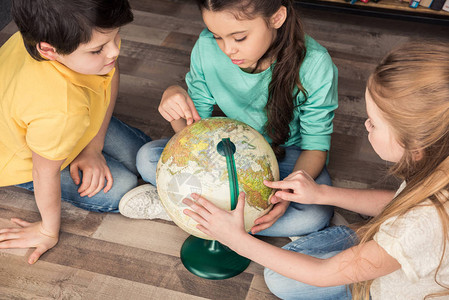 集中儿童在图书馆中探索地球的高图片