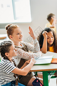 快乐的女学生在上课和举手时坐在教图片