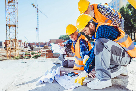 在建筑工地混凝土上坐着身制服的建筑工人图片