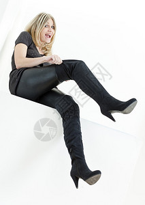 坐着穿时髦黑色靴子的女人图片