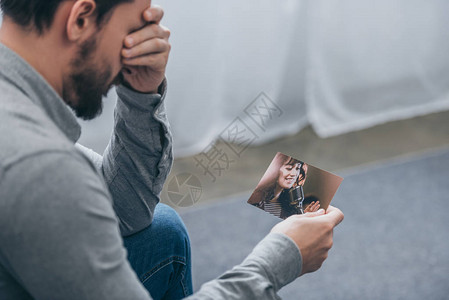悲伤的男子坐在家中与妇女一起拍照背景图片