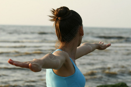 在海滩做瑜伽锻炼的女人图片